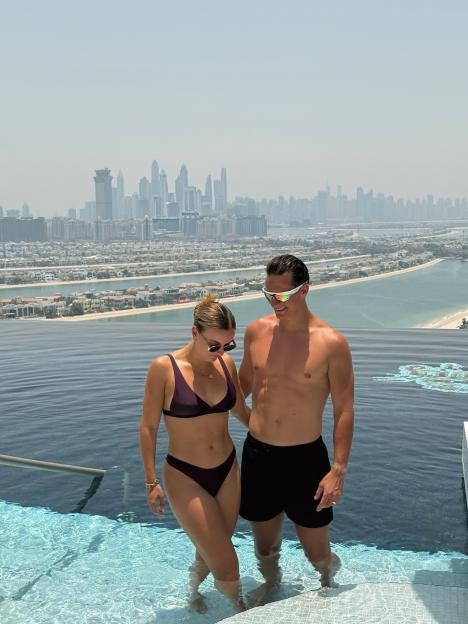 Couple in a infinity pool overlooking Dubai skyline.