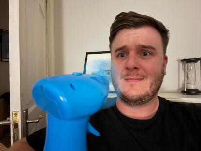 Man holding a blue spray bottle.