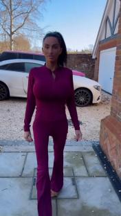 Katie Price walking down a driveway in a purple outfit.