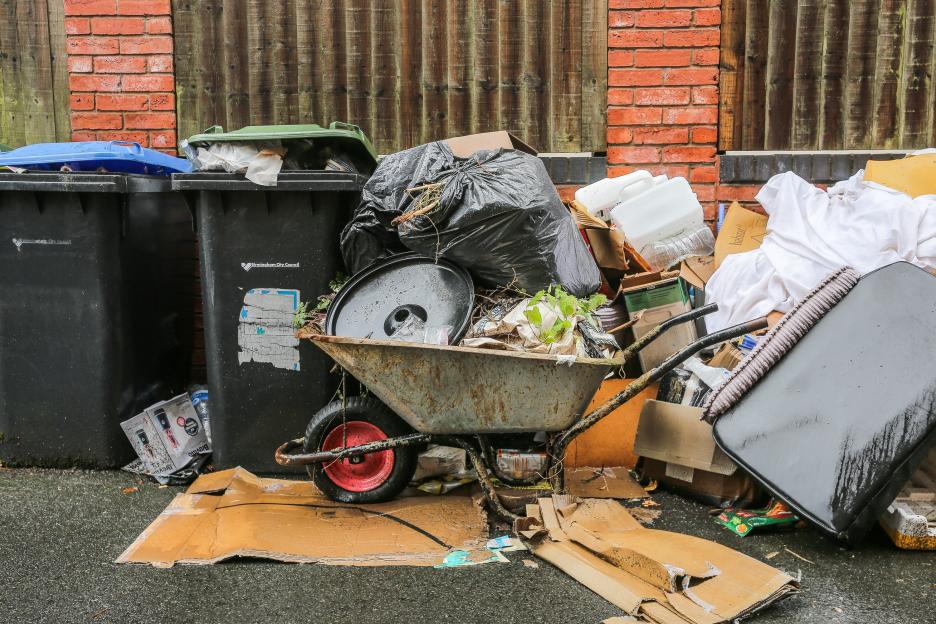Overflowing rubbish and a wheelbarrow filled with waste in Birmingham during a bin strike.