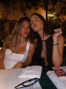 Two women pucker their lips for a kiss.