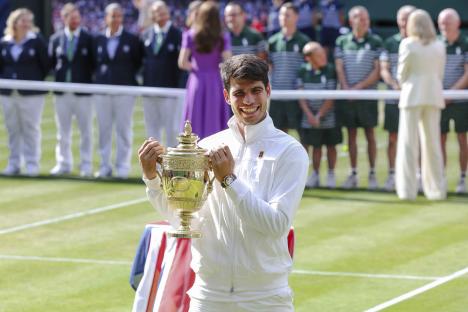 Carlos Alcaraz holding the Wimbledon championship trophy.