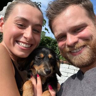 Couple holding a small dog.