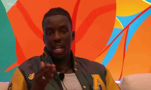 Man speaking in front of an orange and teal background.