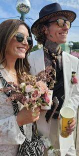 A couple getting married at a festival, surrounded by cheering guests.