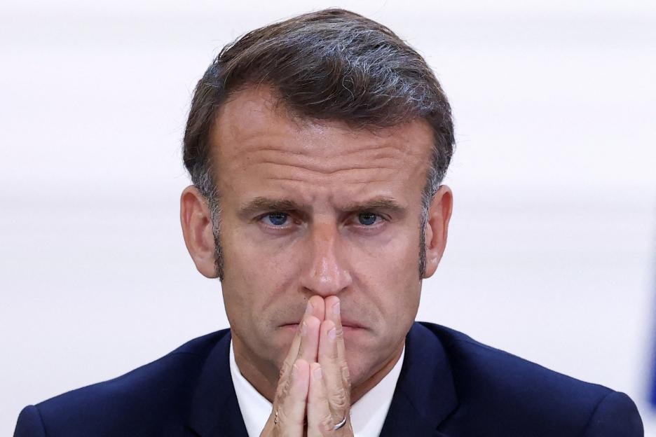 President Emmanuel Macron with hands clasped.