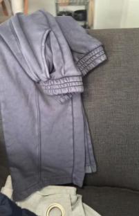 Grey sweatpants folded on a couch.