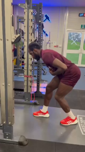 Man doing resistance band exercises in a gym.