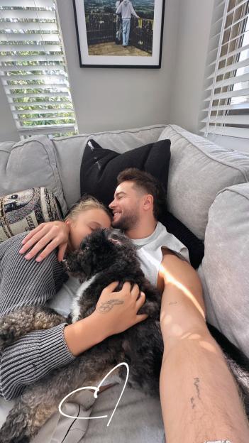Chris Hughes and JoJo Siwa cuddling with their dog.