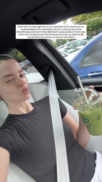 Woman in car holding matcha drink, asking for knee pain remedies.