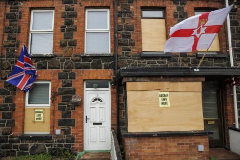 Ballymena houses with boarded windows and signs reading