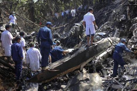 Debris from a plane crash with rescue workers.