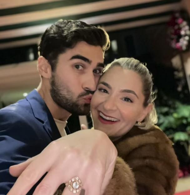 A photo of a couple engaged, the woman showing off her ring.