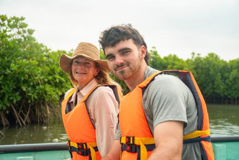 Caroline and Tom wearing life vests on a boat.