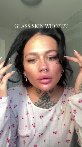 Woman with dark hair and tattoos questioning glass skin.