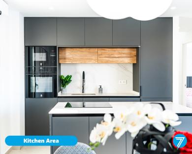 Modern kitchen with dark gray cabinets and wood accents.