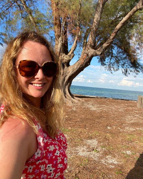 Woman in sunglasses by the ocean.