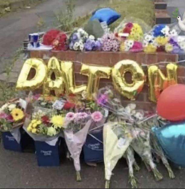 Floral tributes and balloons spelling
