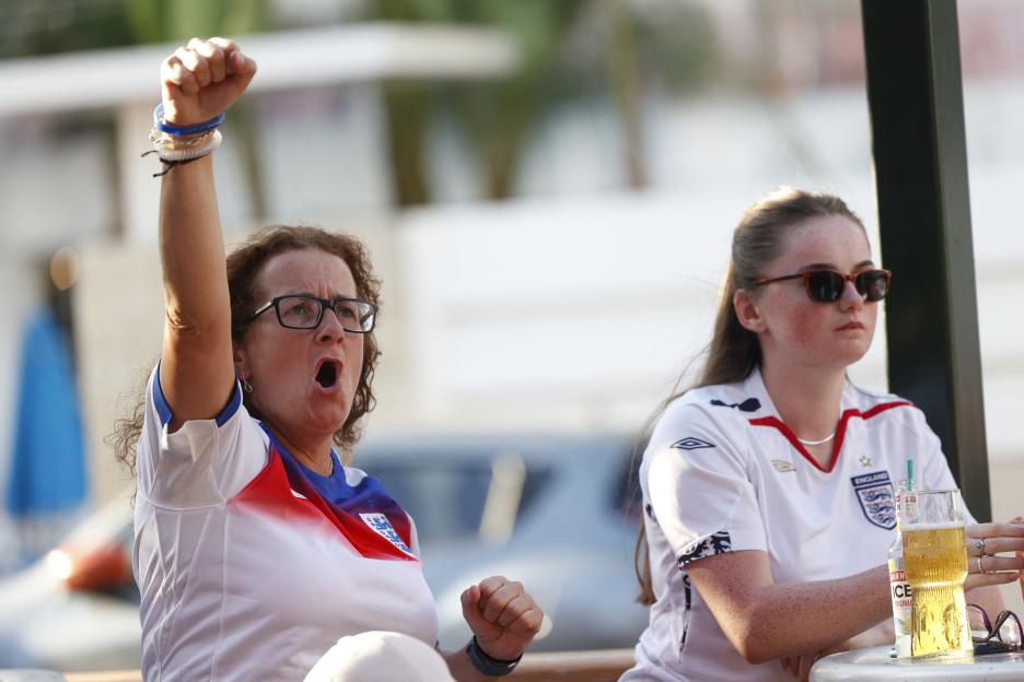 England fans react while watching a soccer match.