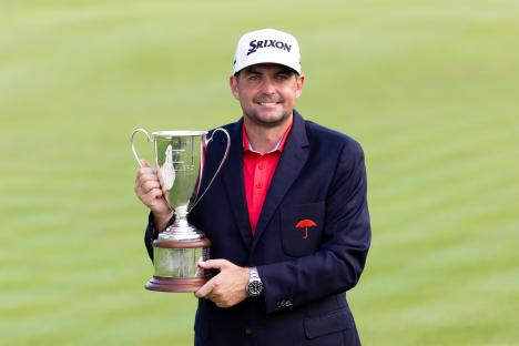 Keegan Bradley holding the Travelers Championship trophy.