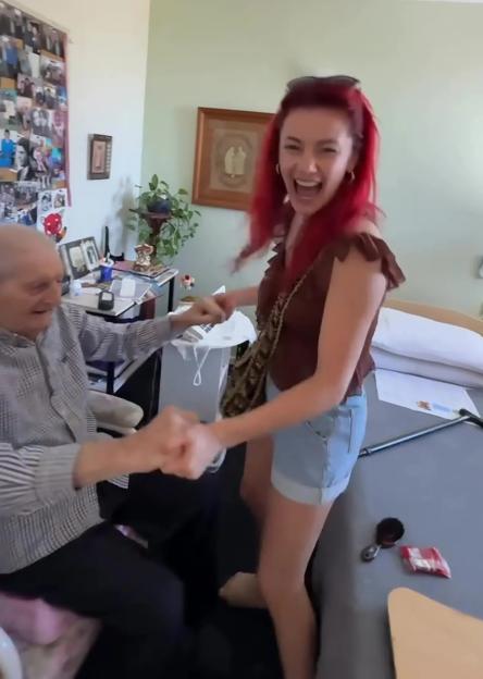 A young woman with red hair fist-bumps her grandfather.