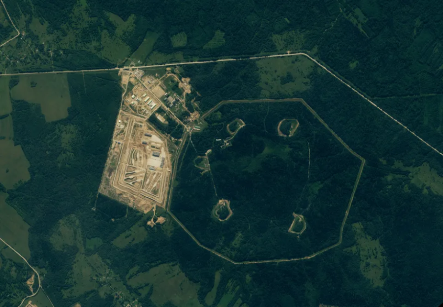 Aerial view of a quarry and surrounding forested area.