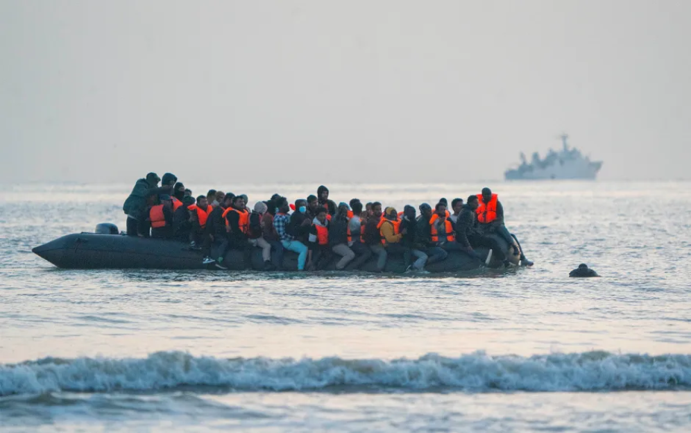 Migrants in a small boat at sea.