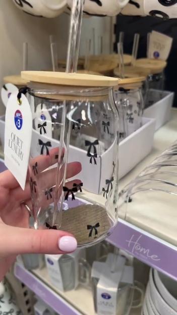 Close-up of a glass cup with a wooden lid and black bow print, from B&M's