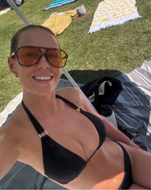 Woman in a black bikini top and sunglasses.