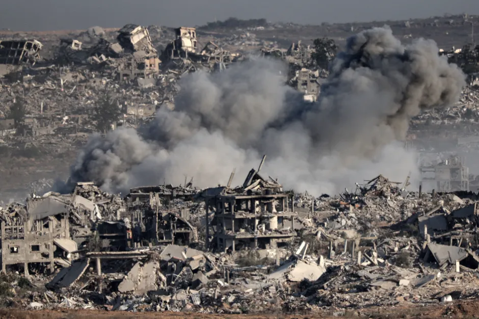 Bomb damage and smoke over rubble-strewn landscape.
