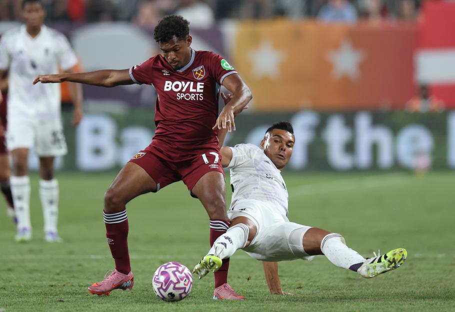 Luis Guilherme of West Ham United challenged by Casemiro of Manchester United during a soccer match.