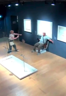 A person breaks a crystal-studded chair in an art gallery.