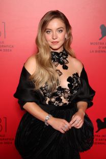 Sydney Sweeney in a dark blue bikini and black stockings.