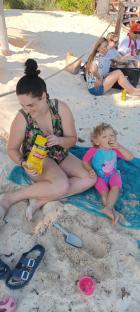 Woman and child on a beach eating snacks.