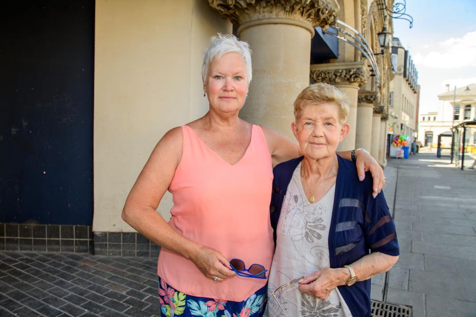 Two women standing together outdoors.