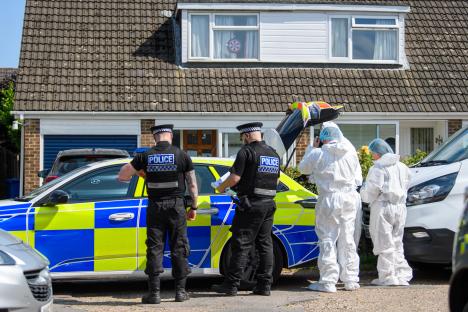 Police officers and forensic investigators at a crime scene.