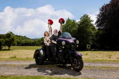 Couple celebrating lottery win on a motorcycle.