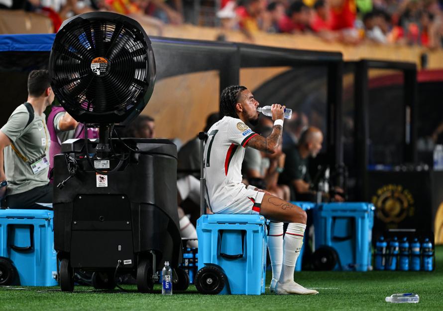 Chelsea FC player Malo Gusto drinks water during a match.