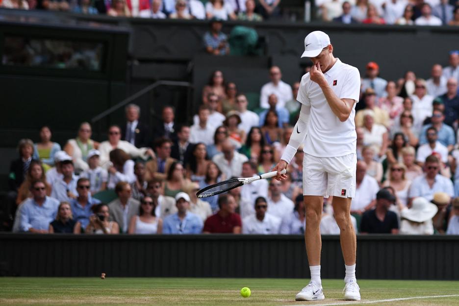 Jannik Sinner at Wimbledon, looking at a cork.