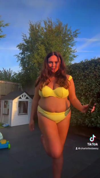 Woman in yellow bikini holding a bottle of tanning product.
