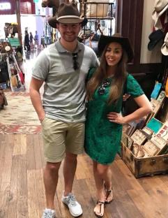 Couple in cowboy hats at a shop.