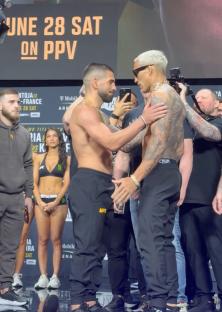 Two MMA fighters facing each other at a weigh-in.