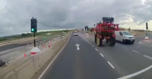 Road under construction with a tractor and van.