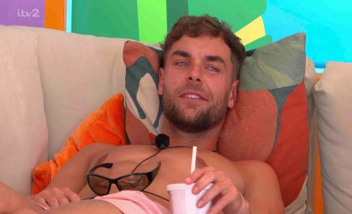 Shirtless man relaxing on a couch.