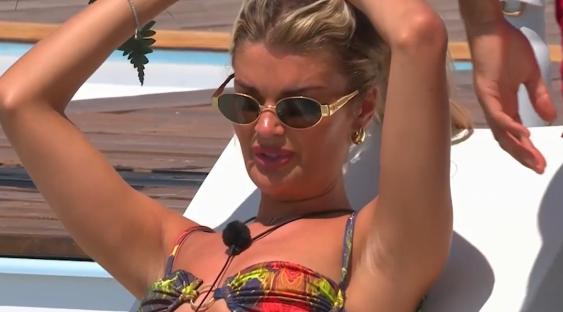 Woman in sunglasses putting her hair up.
