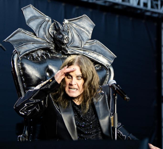 Ozzy Osbourne seated in a bat-shaped chair.