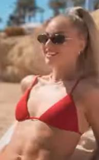 Woman in red bikini adjusting her bra.