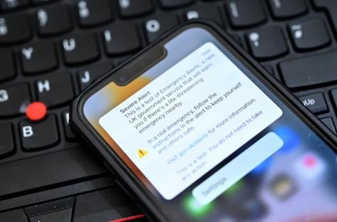 Smartphone displaying a UK government emergency alert test message.