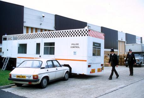 Policemen and police control van at the site of the Brink's-Mat gold bullion robbery at Heathrow Airport.