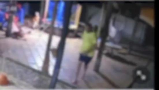 Blurry security camera footage of a person standing near a group of people.